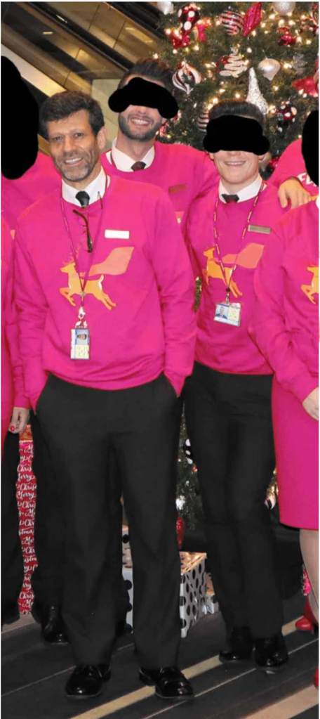 three male cabin crew wearing pink sweatshirts 