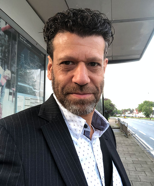 middle aged man in a suit smiling for a selfie