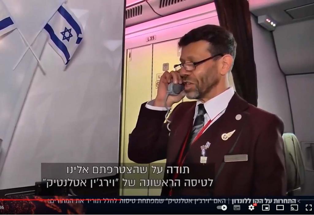 male flight attendant making an announcement on the aircraft
